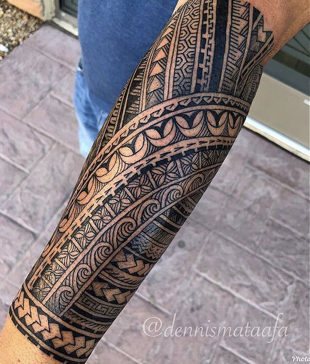 traditional polynesian tattoo owl and wave arm tattoo